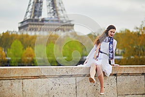 Woman in white dress near the Eiffel tower in Paris, France