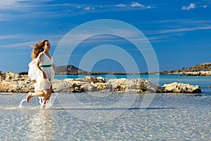 Woman in a white dress runs on the water
