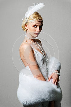 Woman in white dress with shoulder straps and long fur boa