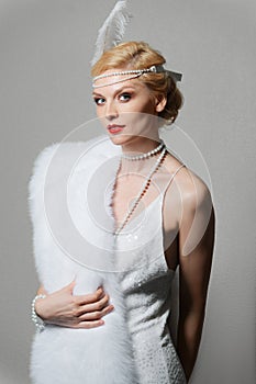 Woman in white dress with shoulder straps and long fur stole