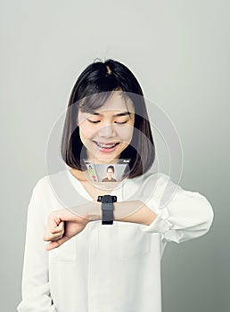 Woman in a white dress show digital clock displaying digital screens to communicate face-to-face.