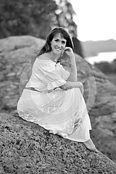 Woman in a white dress sitting, vintage monochrome portrait