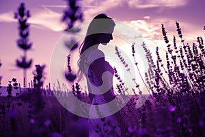 a woman in a white dress is standing in a field of purple flowers at sunset