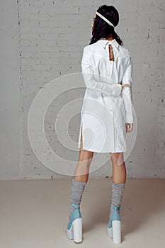 Woman in white dress- straitjacket turning away