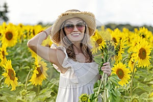 woman in a white dress and sunglasses with a bouquet in the field of sunflowers in Yorkshire