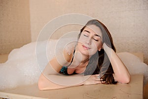 Woman in white foam relaxing in a hamam