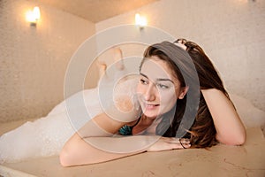 Woman in white foam relaxing in a hamam