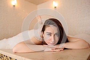 Woman in white foam relaxing in a hamam