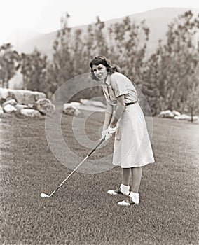 Woman in white gloves playing golf photo