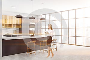 Woman in white and gray kitchen corner with bar