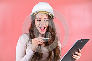 Woman in white hardhat writes information for project