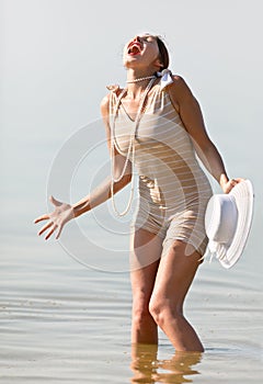 Woman in white hat cried against the sea