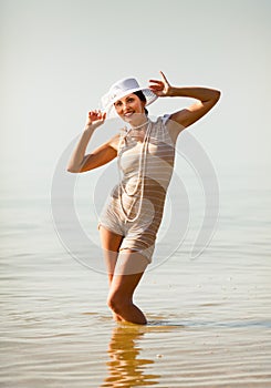 Woman in white hat posing against the sea