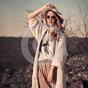 Woman in white hat and sunglasses posing outdoors