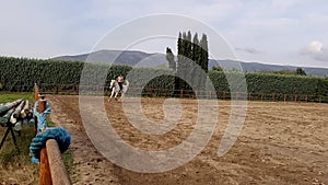 Woman on white horse doing horseback riding.