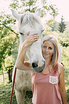 Woman with white horse outdoor.