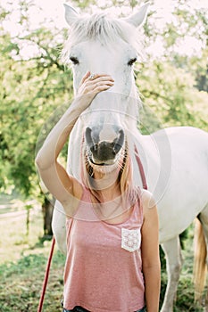 Woman with white horse outdoor.