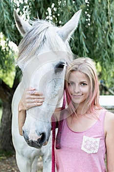 Woman with white horse outdoor.