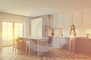 Woman in white kitchen with bar