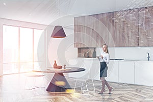 Woman in white kitchen corner with round table