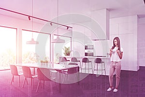 Woman in white kitchen corner with table and bar