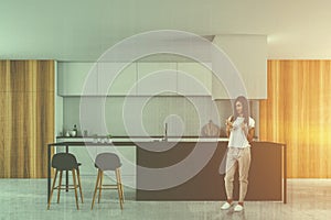 Woman in white kitchen interior with bar