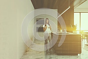 Woman in white kitchen with island