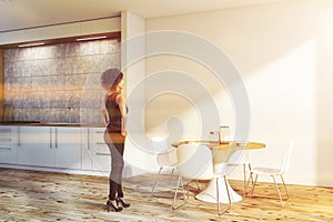 Woman in white kitchen with round table