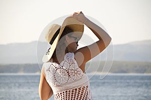 Woman in white lace dress holdin a hat