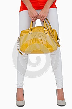 Woman in white leggings holding yellow bag