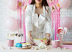Woman in white party clothes preparing birthday table