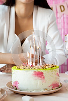 Woman in white party clothes preparing birthday table