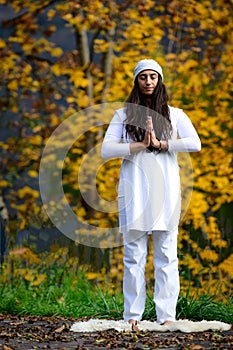 Woman in white practices yoga in the nature in autumn photo