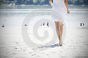 Woman in white running on beach