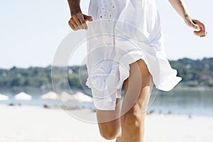 Woman in white running on beach