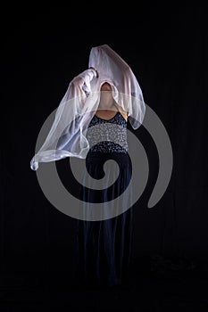 Woman with a white scarf on a black background.