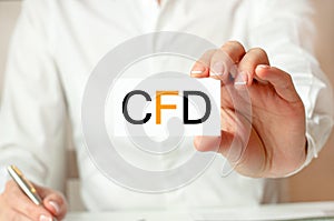 A woman in a white shirt holds a piece of paper with the text: cfd. Business concept