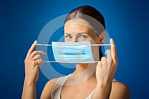 Woman in white shirt shows how to wear a mask during a pandemic