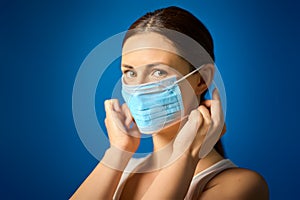 Woman in white shirt shows how to wear a mask during a pandemic