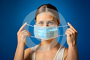 Woman in white shirt shows how to wear a mask during a pandemic