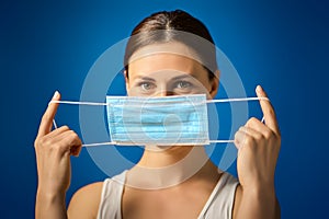 Woman in white shirt shows how to wear a mask during a pandemic