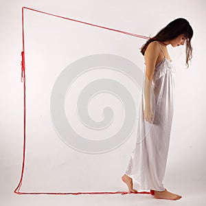 Woman white silk nightie lifting pulling red thread on white background