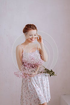 Woman in a white simple dress with a bouquet of flowers