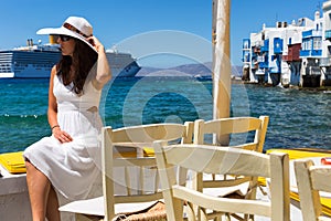 Woman in white sits at the waterfront of Little Venice in Mykonos