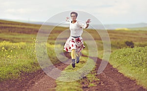 Woman in white skirt running on a countryside road