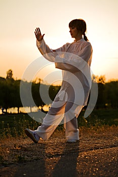 Woman in white suit make's taiji chuan - 10 photo