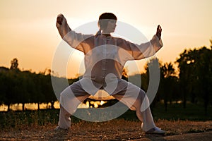 Woman in white suit make's taiji chuan - 3 photo