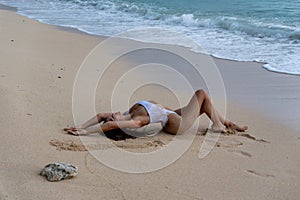 Woman in White Swimsuit Relaxing on Sand