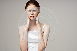 woman in white t-shirt holding head migraine disorder isolated background