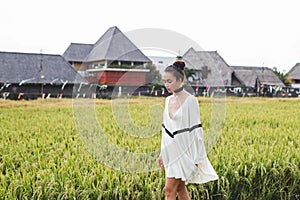 Woman in white tunic in rice fields Bali Tegallalang. Rustic Ubud village